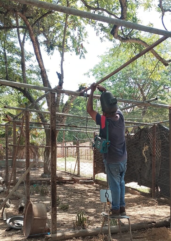 un soldador trabaja en las nuevas estructuras metalicas de los nuevos recintos etológicos en el reservorio Fundo Flor de Coco