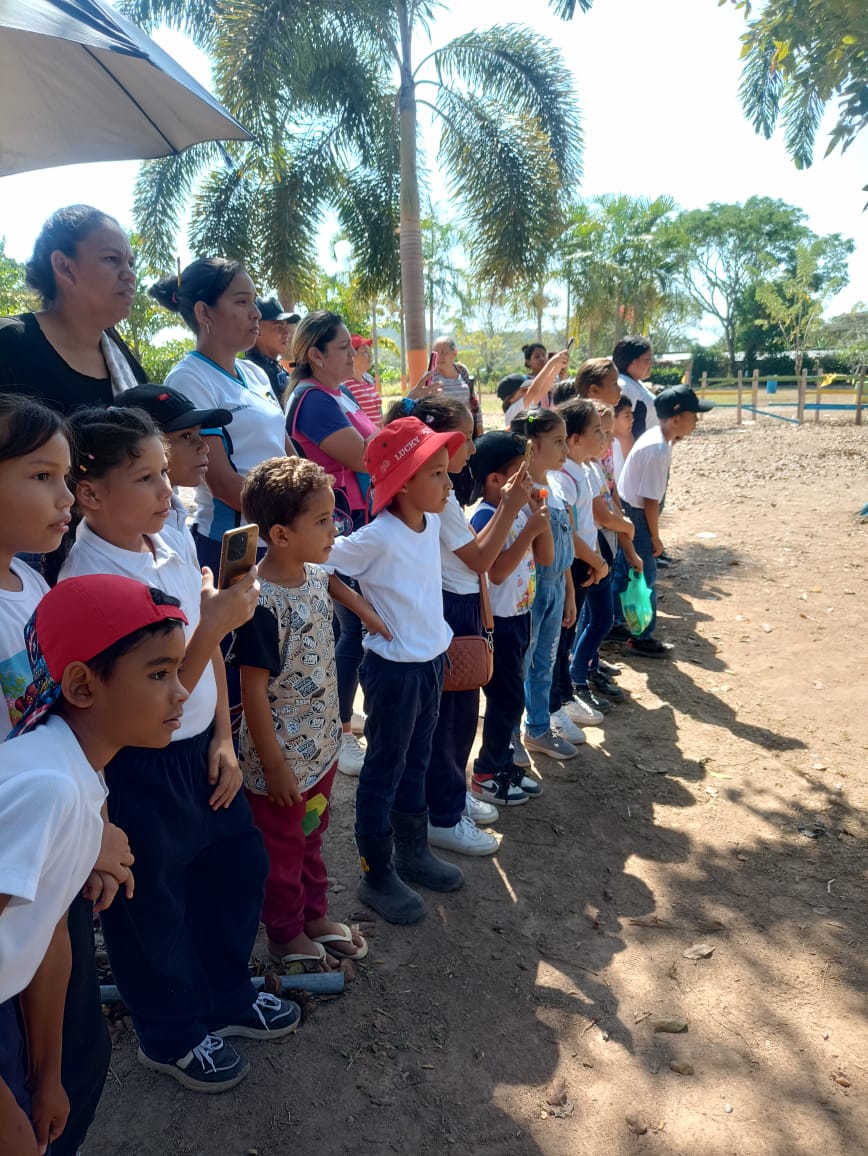 niños de escuela primaria con sus maestras toman videos con sus telefonos en una visita al reservorio Fundo Flor de Coco